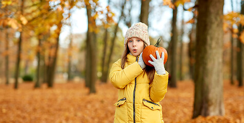 Image showing happy girl with pumpkin at autumn park