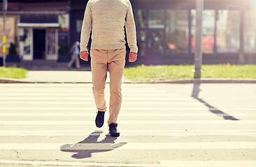 Image showing senior man walking along city crosswalk