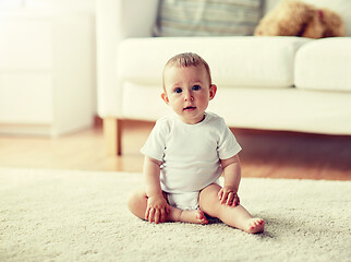 Image showing happy baby boy or girl sitting on floor at home