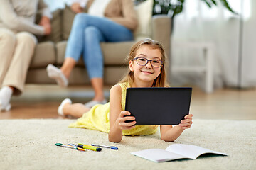 Image showing student girl with tablet pc lying on floor at home