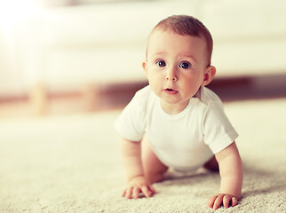 Image showing little baby in diaper crawling on floor at home