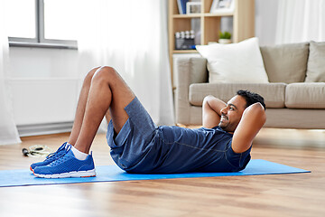 Image showing indian man making abdominal exercises at home