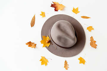 Image showing hat and fallen autumn leaves on white background