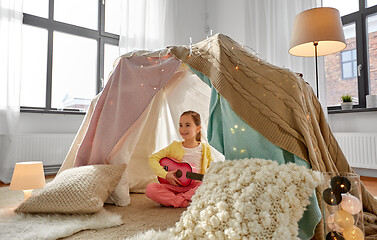 Image showing little girl playing guitar in kids tent at home