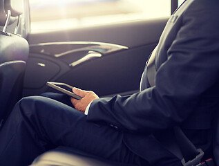 Image showing senior businessman with tablet pc driving in car