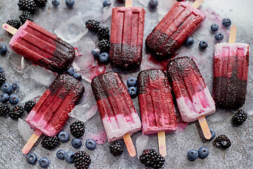 Image showing Homemade blackberry and cream ice-creams or popsicles with frozen berries on black slate tray