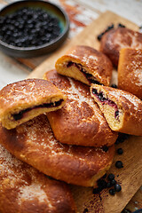 Image showing Tasty blueberry bun stuffed with fresh forrest fruits. Traditional polish bun called jagodzianka