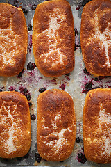 Image showing Delicious hot homemade buns stuffed with blueberry on a baking tray