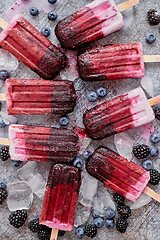 Image showing Homemade blackberry and cream ice-creams or popsicles with frozen berries on black slate tray