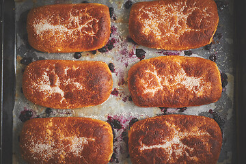 Image showing Delicious hot homemade buns stuffed with blueberry on a baking tray