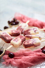 Image showing Homemade vegan cherry popsicles with coconut milk. Placed on ceramic plate