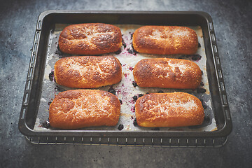 Image showing Delicious hot homemade buns stuffed with blueberry on a baking tray