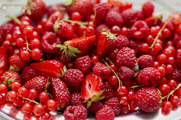 Image showing Fresh summer red fruit background composition. Strawberries, red currants, raspberries.