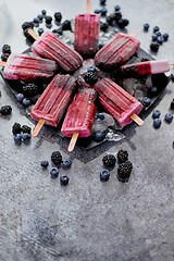 Image showing Forrest fruit ice cream on stick. Homemade healthy vegan snack. Placed on plate with ice