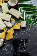 Image showing Homemade pineapple coconut popsicles on stone background. Summer food concept with copy space