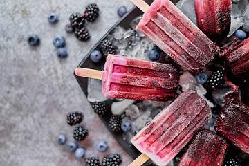 Image showing Forrest fruit ice cream on stick. Homemade healthy vegan snack. Placed on plate with ice