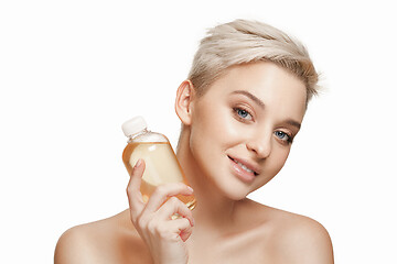 Image showing Beauty concept. The pretty woman with perfect skin holding oil bottle