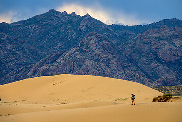 Image showing Traveler in desert dunes in mountains