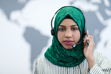 Image showing African muslim female with phone headset helping and supporting 