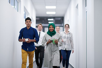 Image showing multi-ethnic startup business team walking through the hallway