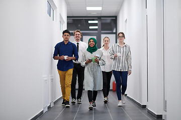 Image showing multi-ethnic startup business team walking through the hallway