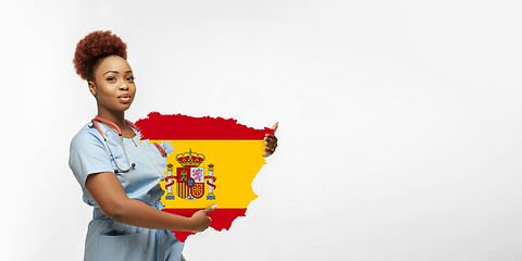Image showing Beautiful african-american doctor cares about Spain isolated over white studio background
