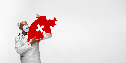 Image showing Beautiful african-american doctor cares about Switzerland isolated over white studio background