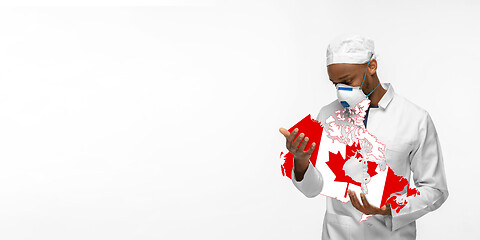 Image showing Beautiful african-american doctor cares about Canada isolated over white studio background