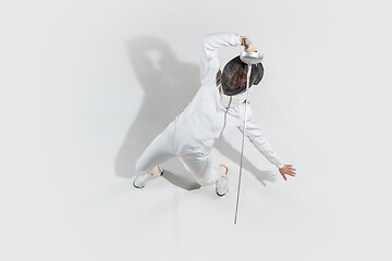 Image showing Teen girl in fencing costume with sword in hand isolated on white background, top view