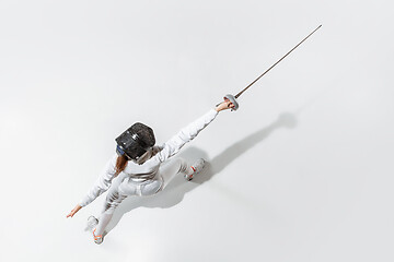 Image showing Teen girl in fencing costume with sword in hand isolated on white background, top view