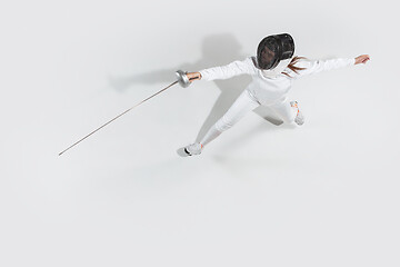 Image showing Teen girl in fencing costume with sword in hand isolated on white background, top view