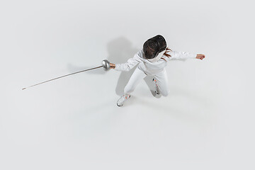 Image showing Teen girl in fencing costume with sword in hand isolated on white background, top view