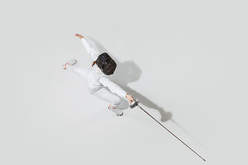 Image showing Teen girl in fencing costume with sword in hand isolated on white background, top view