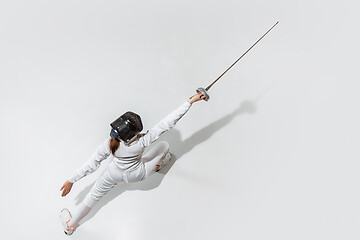 Image showing Teen girl in fencing costume with sword in hand isolated on white background, top view