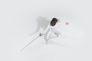 Image showing Teen girl in fencing costume with sword in hand isolated on white background, top view