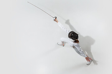 Image showing Teen girl in fencing costume with sword in hand isolated on white background, top view