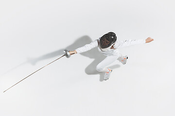 Image showing Teen girl in fencing costume with sword in hand isolated on white background, top view