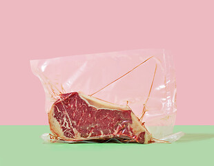 Image showing steak in cellophane packaging on a colored background