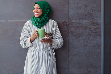 Image showing african muslim businesswoman with green hijab using mobile phone