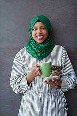 Image showing african muslim businesswoman with green hijab using mobile phone