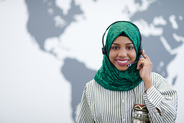 Image showing African muslim female with phone headset helping and supporting 