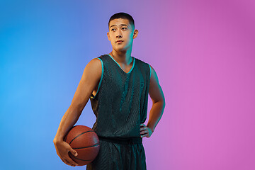 Image showing Young basketball player in motion on gradient studio background in neon light