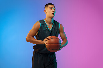 Image showing Young basketball player in motion on gradient studio background in neon light