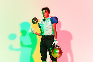 Image showing American football player isolated on gradient studio background in neon light with shadows