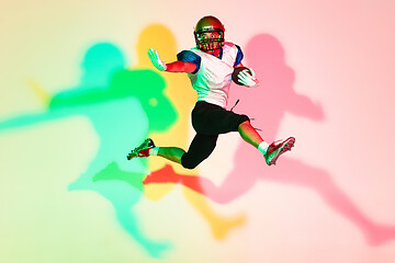 Image showing American football player isolated on gradient studio background in neon light with shadows