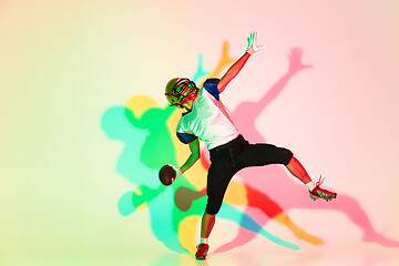 Image showing American football player isolated on gradient studio background in neon light with shadows