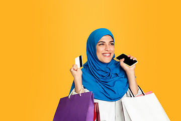 Image showing Portrait of young muslim woman isolated on yellow studio background