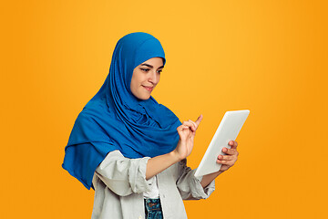 Image showing Portrait of young muslim woman isolated on yellow studio background