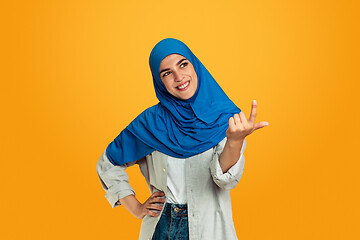 Image showing Portrait of young muslim woman isolated on yellow studio background