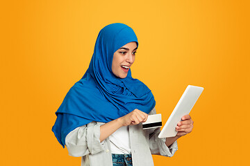 Image showing Portrait of young muslim woman isolated on yellow studio background